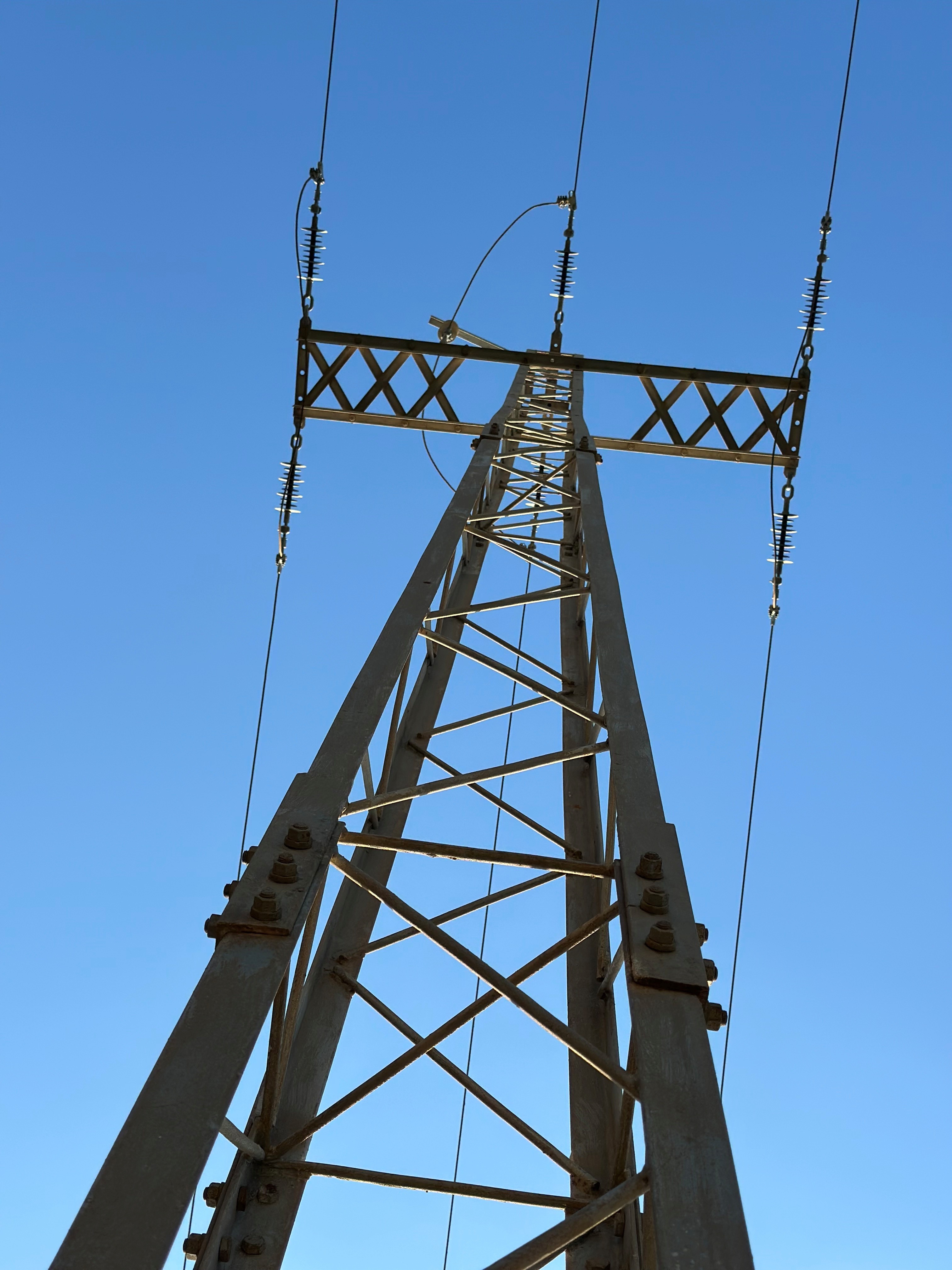 Strommast vor blauem Himmel